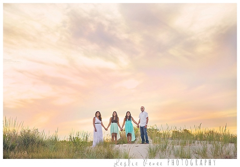 family of four with beautiful colorful sky
