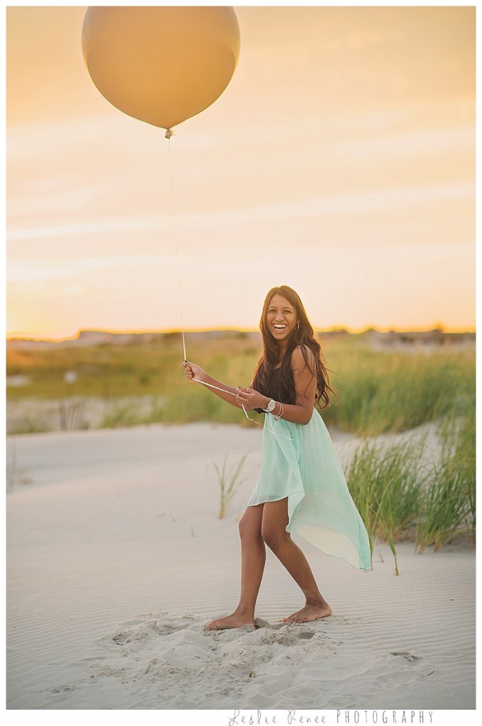 Oceanside girl plays with balloon on beach