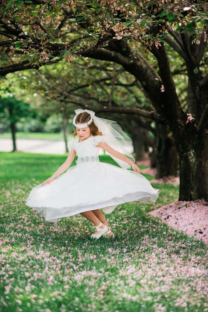 communion girl spinning by cherry trees