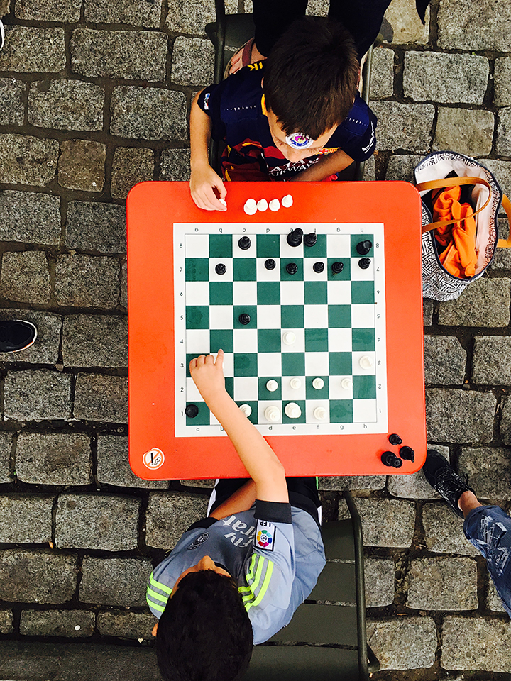 Keaton and Matthew playing chess in Quincy Market