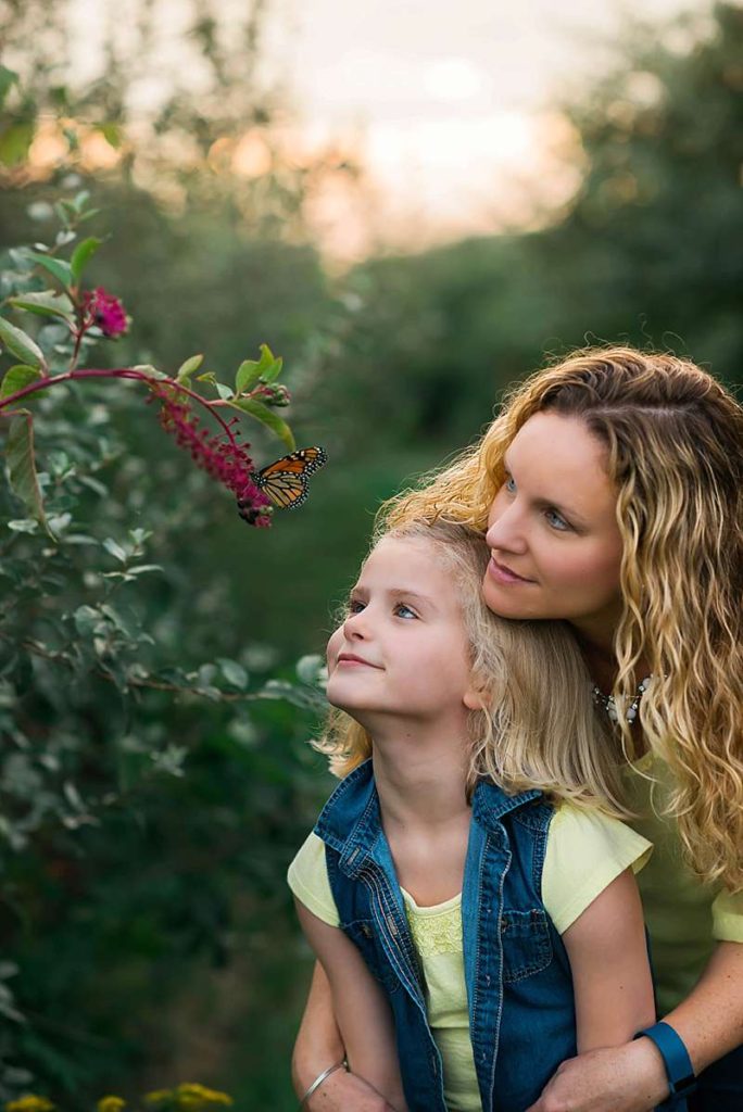 mom and daughter see butterfly