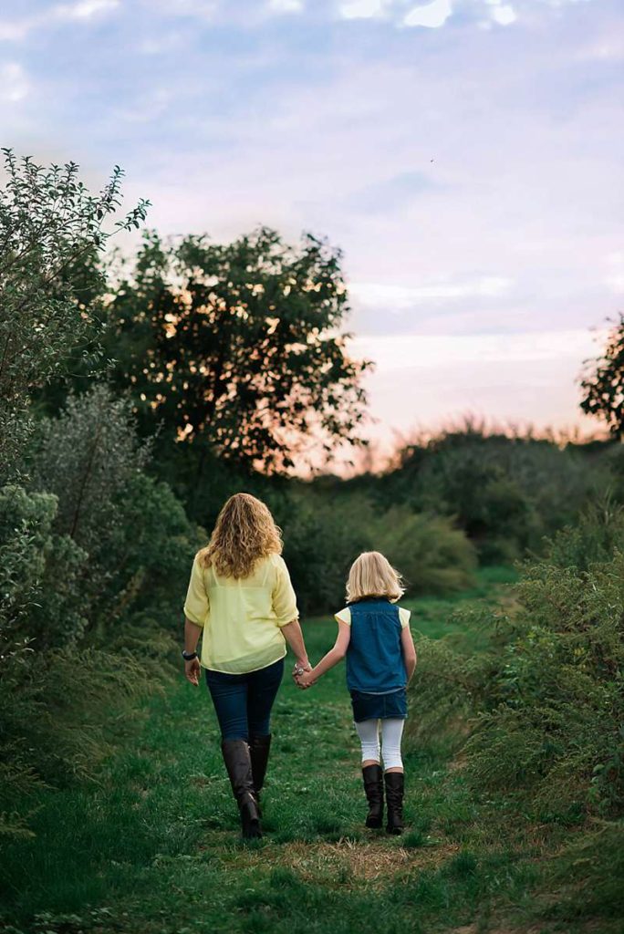 mom and daughter walking off into the sunset