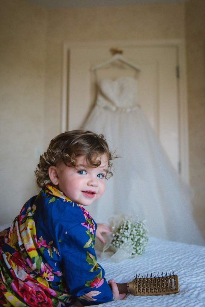 Fun Long Island Wedding Photographer baby girl with mom's wedding dress