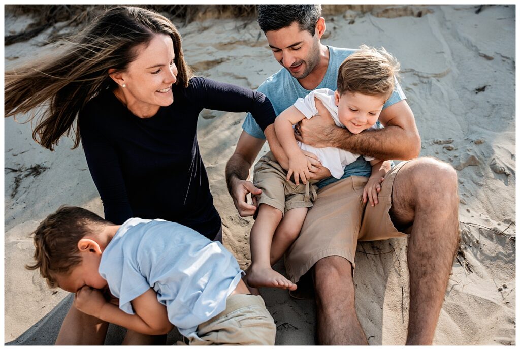 little boys on the beach with mom and dad tickle