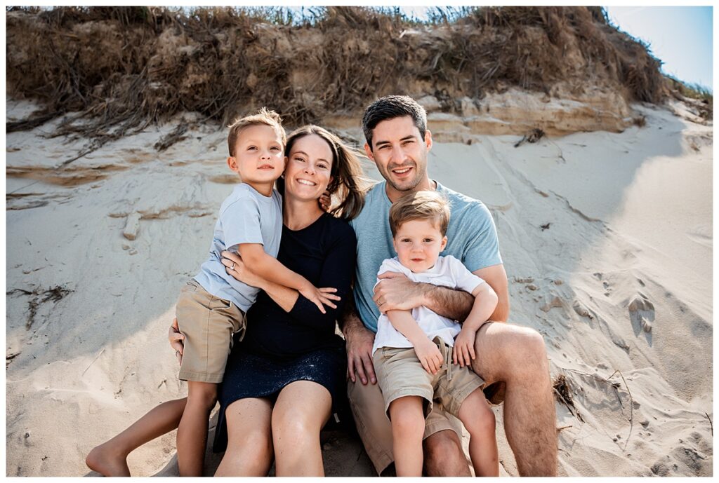 little boys on the beach with mom and dad in the sand