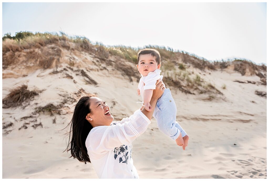 two moms and baby boy family photos on the beach fun pose