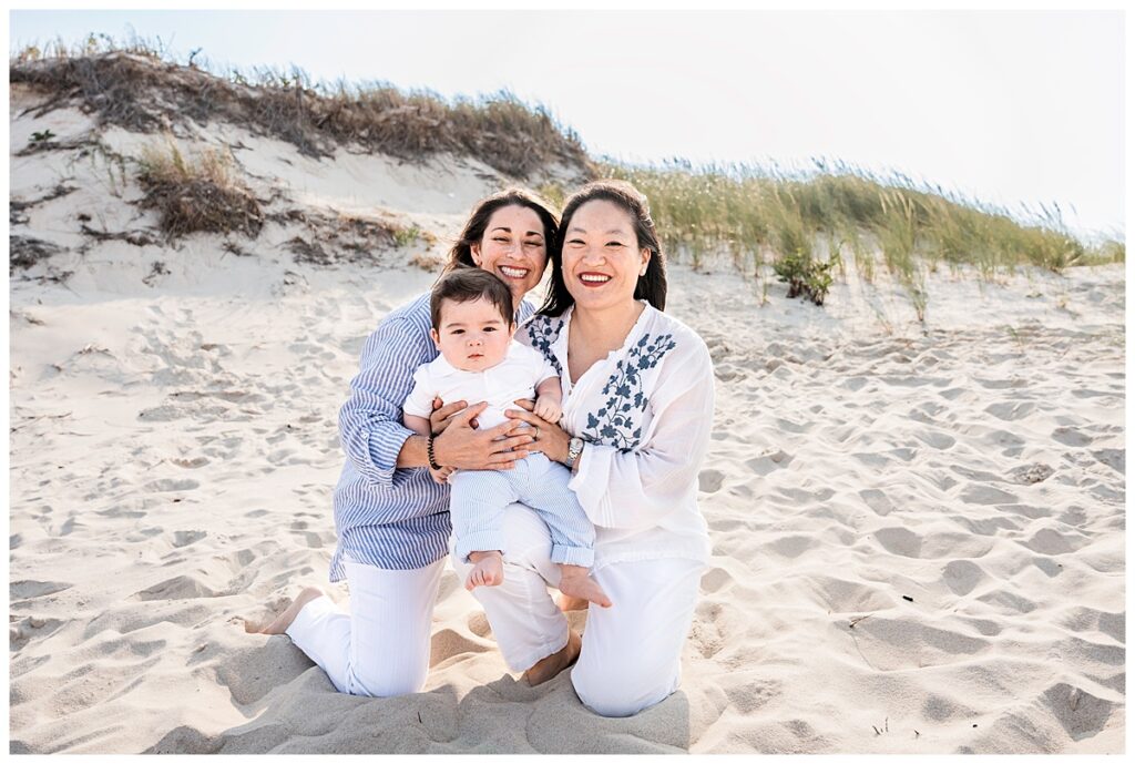 two moms and baby boy family photos on the beach sitting pose
