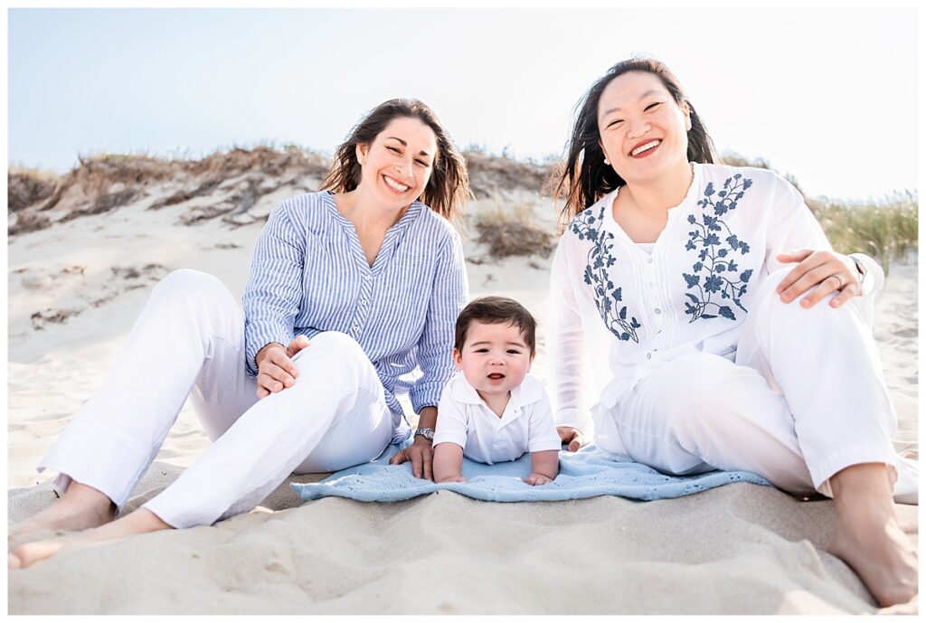two moms and baby boy family photos on the beach blanket