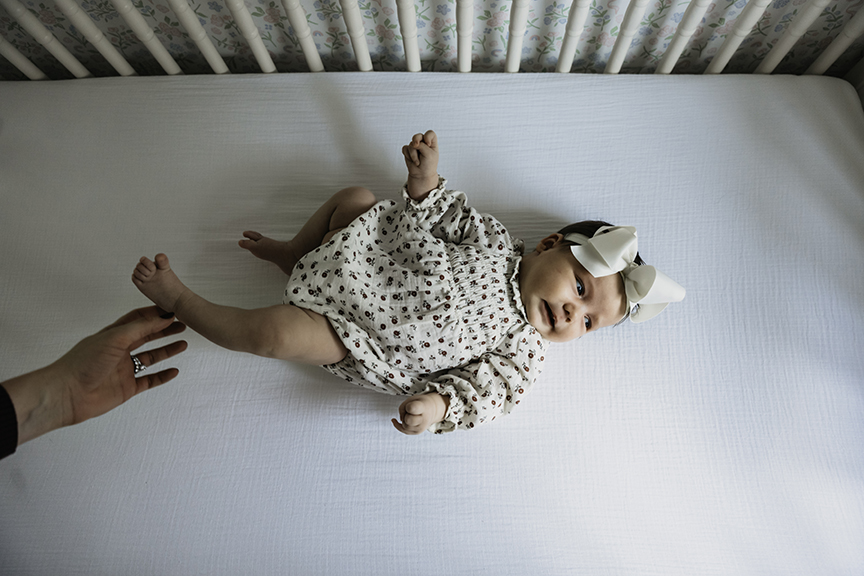 Cozy and Playful In Home New Baby Photos in the crib